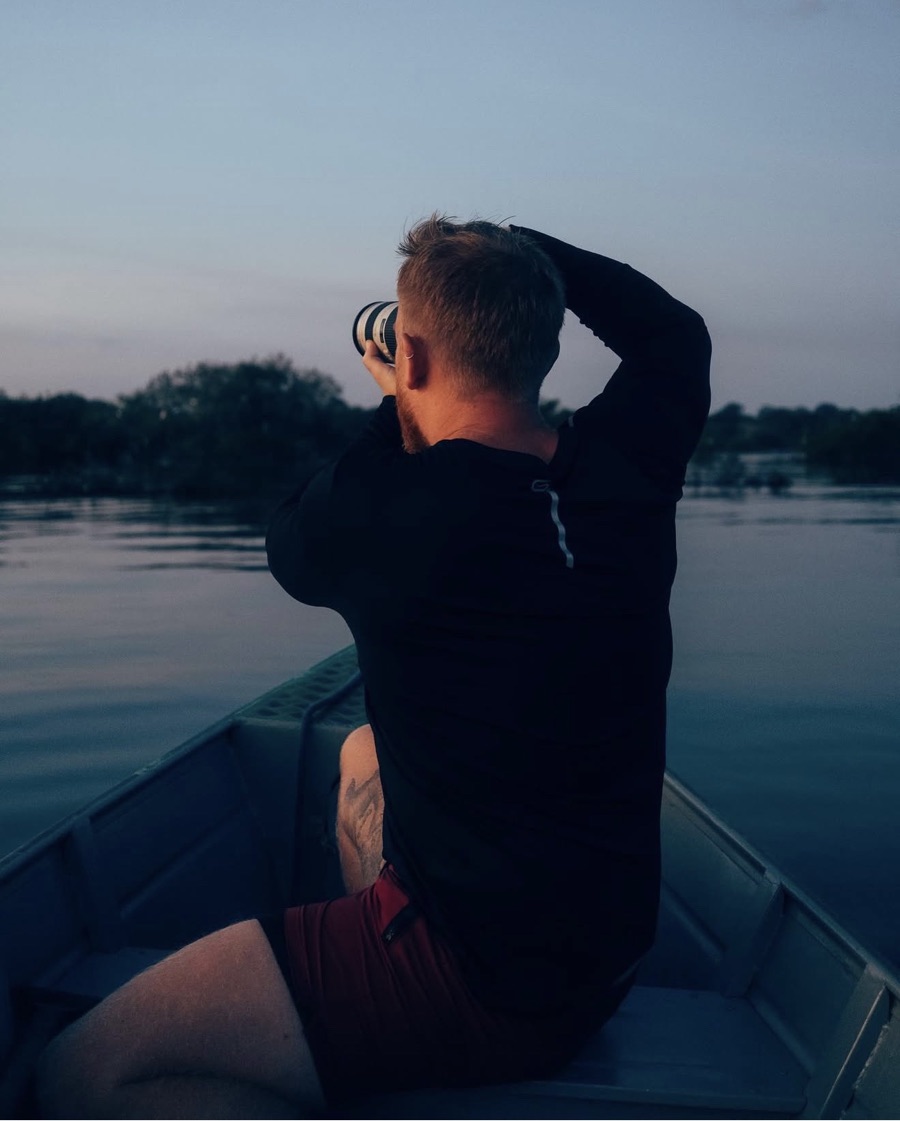 Francisco photographing from a boat in the Amazon